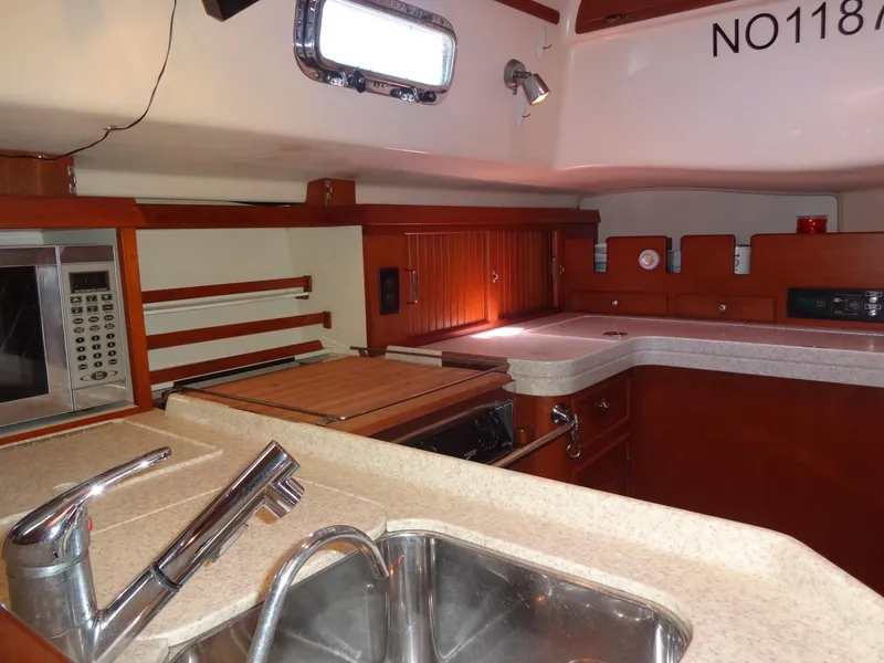 Slide: The Image of Interior of 2006 Island Packet 440 yacht kitchen with sink, microwave, and wooden cabinetry. - 12