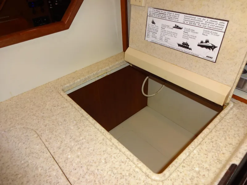 Slide: The Image of 2006 Island Packet 440 yacht interior with open storage compartment and safety notice. - 18