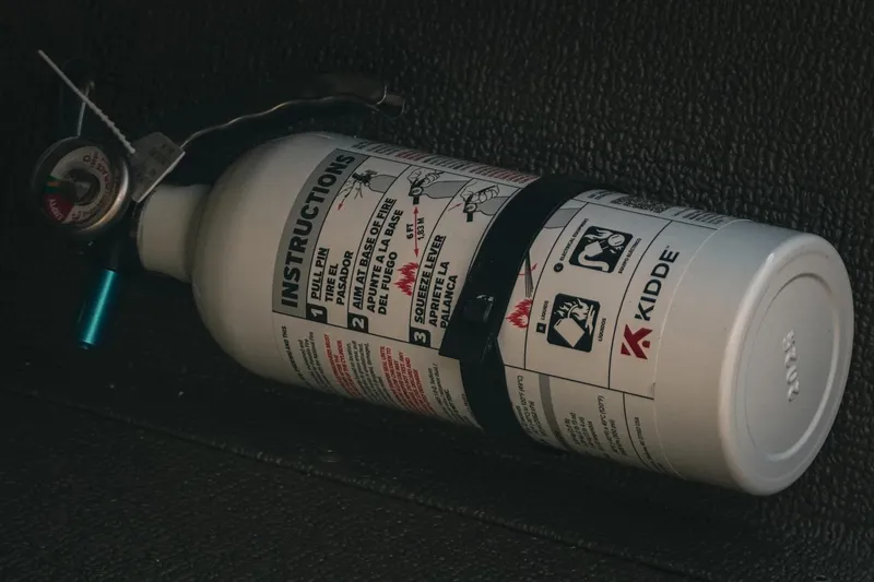 Slide: The Image of Fire extinguisher with instructions, labeled "Kidde," on a dark surface. - 22