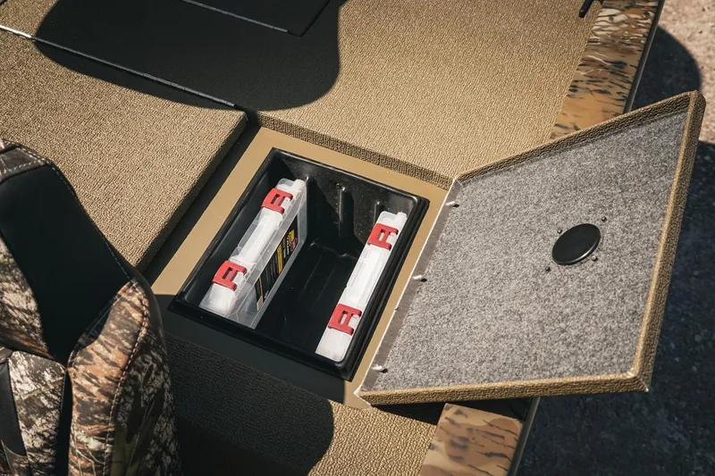 Slide: The Image of 2026 G3 Sportsman 1710 boat storage compartment with open lid and organized tackle boxes. - 28