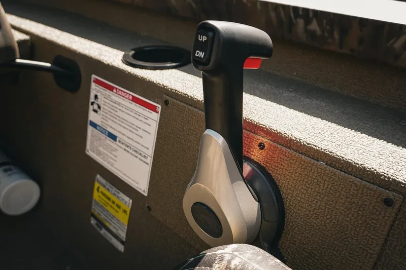 Slide: The Image of Control lever on 2026 G3 Sportsman 1710 boat, with warning labels and cup holder. - 31