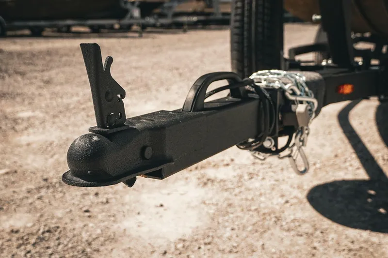 Slide: The Image of Trailer hitch of 2026 G3 Sportsman 1710 with safety chains on gravel surface. - 42