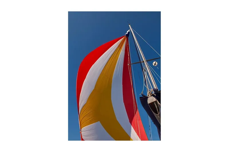 Slide: The Image of Colorful sail of 1981 Jensen Marine/Cal Boats 39 MK III against clear blue sky. - 2