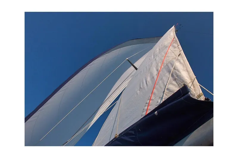 Slide: The Image of Sails of a 1981 Jensen Marine/Cal Boats 39 MK III against a clear blue sky. - 3