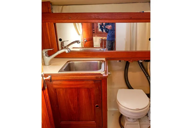Slide: The Image of 1981 CAL 39 MK III yacht bathroom with wooden cabinetry, sink, and toilet. - 34