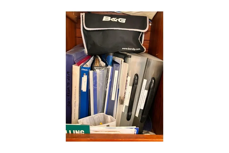 Slide: The Image of Storage compartment with binders and a B&G bag on a 1981 Jensen Marine/Cal Boats 39 MK III. - 42