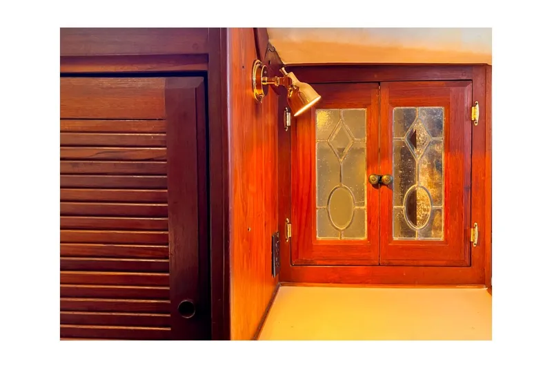 Slide: The Image of 1981 Jensen Marine/Cal Boats 39 MK III interior with wooden cabinet and decorative glass doors. - 49