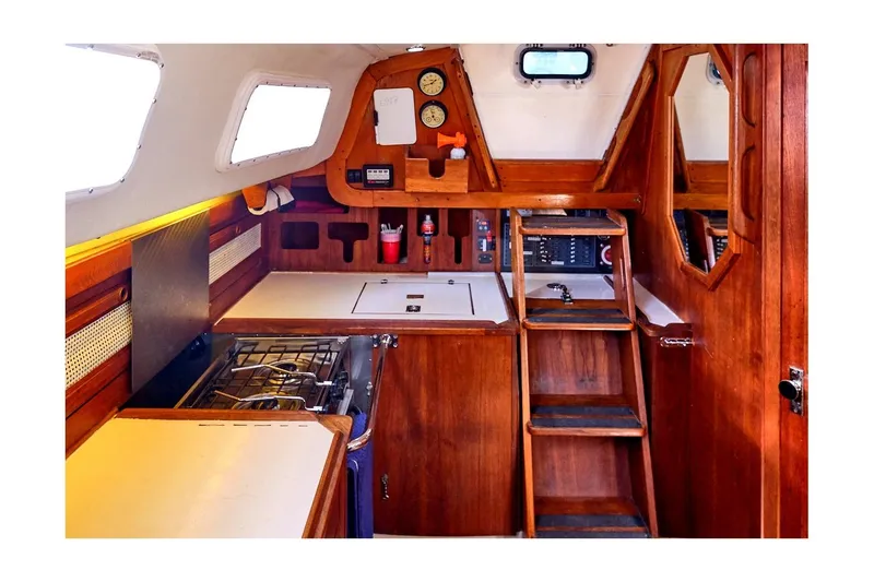 Slide: The Image of Interior of 1981 CAL 39 MK III sailboat, featuring wooden cabinetry and compact kitchen area. - 50