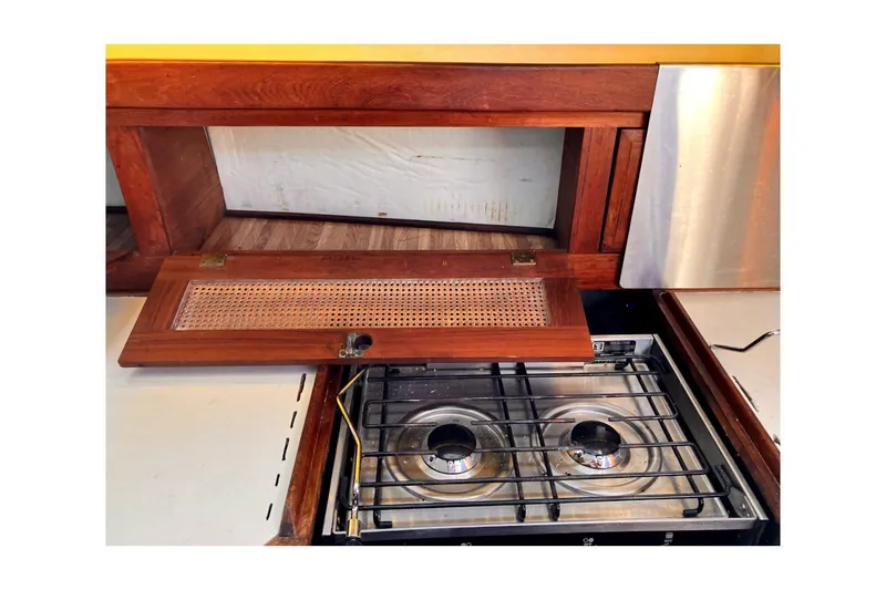 Slide: The Image of 1981 Jensen Marine/Cal Boats 39 MK III galley with two-burner stove and wooden cabinetry. - 53