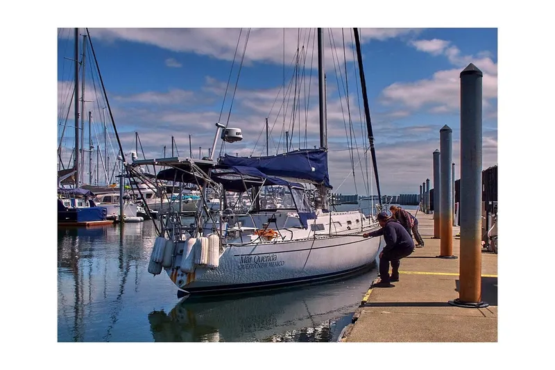 Slide: The Image of 1981 Jensen Marine/Cal Boats 39 MK III sailboat docked at marina with people nearby. - 76