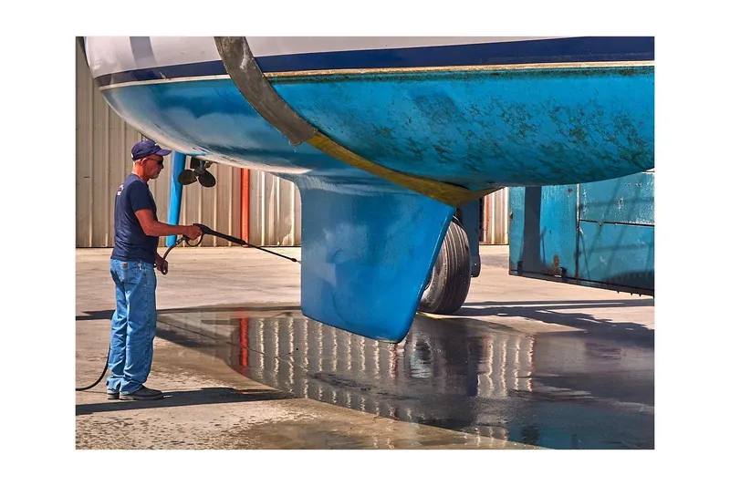 Slide: The Image of Man cleaning 1981 Jensen Marine/Cal Boats 39 MK III sailboat hull with pressure washer. - 77