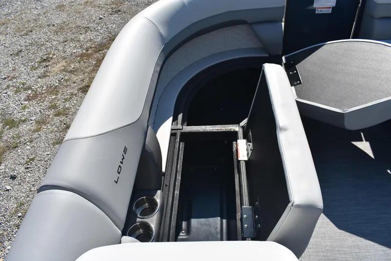 Slide: The Image of 2026 Lowe SS 230 WV boat interior with open storage compartment and cup holders. - 19