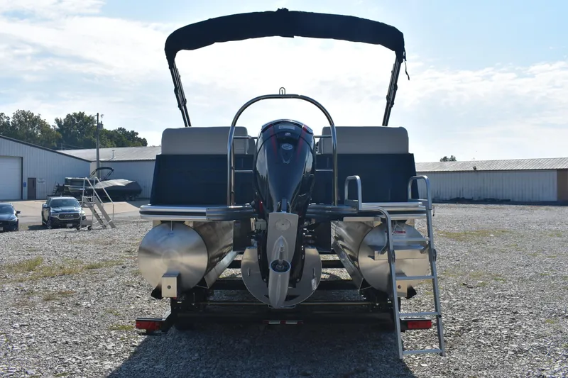 Slide: The Image of 2026 Lowe SS 230 WV pontoon boat with outboard motor and ladder, parked on gravel. - 4