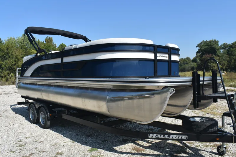 Slide: The Image of 2026 Lowe SS 230 WV pontoon boat on Haul-Rite trailer, parked outdoors. - 6