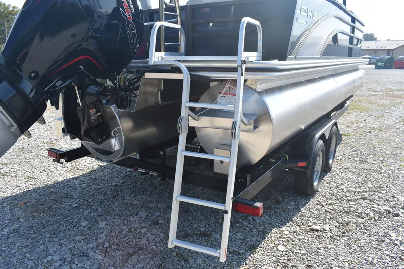 Slide: The Image of 2026 Lowe SS 230 WV pontoon boat with ladder and outboard motor on gravel. - 7