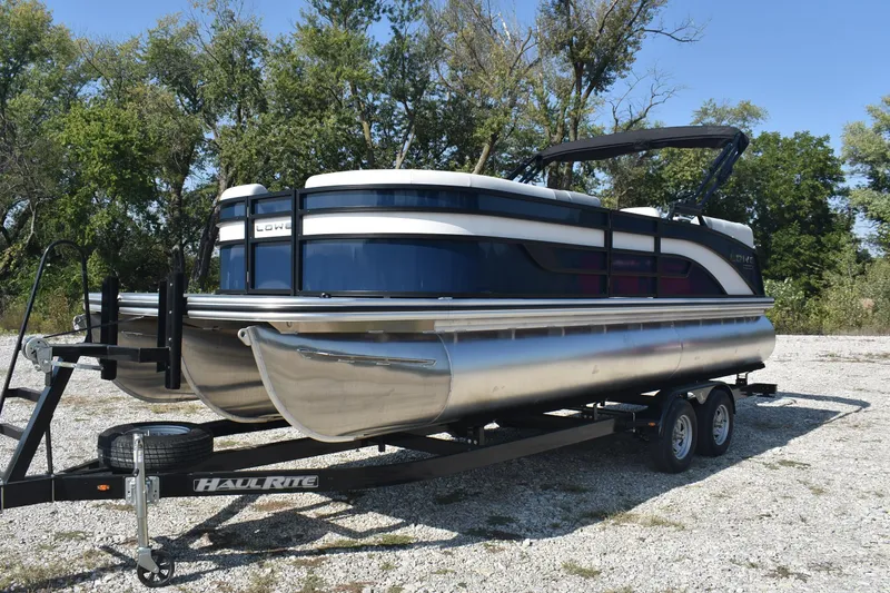 Slide: The Image of 2026 Lowe SS 230 WV pontoon boat on trailer, surrounded by trees. - 8