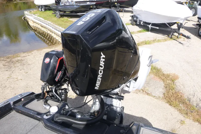 Slide: The Image of 2023 Nitro ZV21 boat with Mercury 400 outboard engine at a lakeside dock. - 13