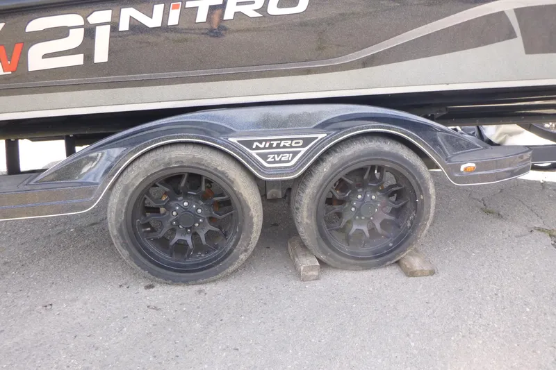Slide: The Image of Trailer wheels of a 2023 Nitro ZV21 boat on wooden blocks. - 24