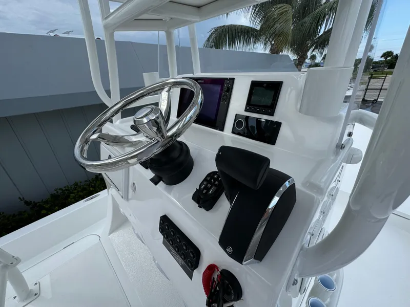 Slide: The Image of 2025 Shallow Sport 25 X3 boat console with steering wheel and navigation system. - 11