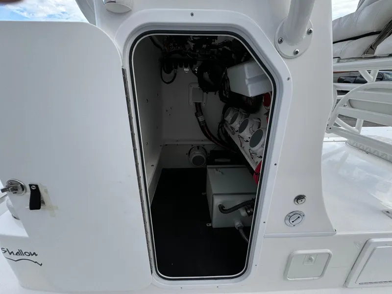Slide: The Image of 2026 Shallow Sport 25 X3 boat with open storage compartments on water. - 19