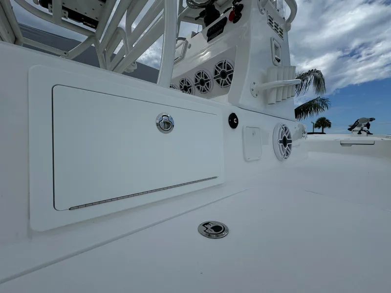 Slide: The Image of 2026 Shallow Sport 25 X3 boat with Mercury engine, parked on wet pavement. - 7