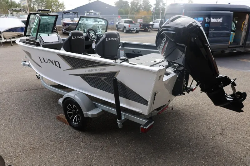 Slide: The Image of 2026 Lund 1775 Adventure Sport boat on trailer, featuring sleek design and powerful outboard motor. - 11