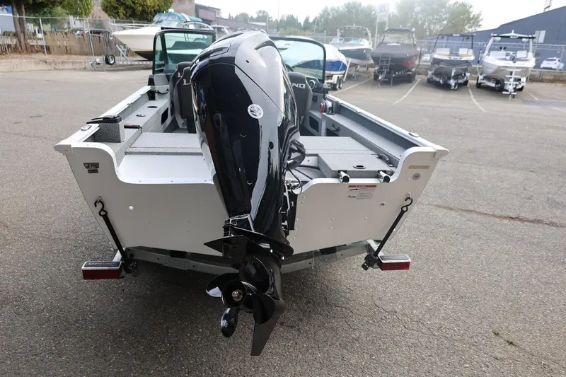Slide: The Image of 2026 Lund 1775 Adventure Sport boat with outboard motor, parked in a marina. - 13