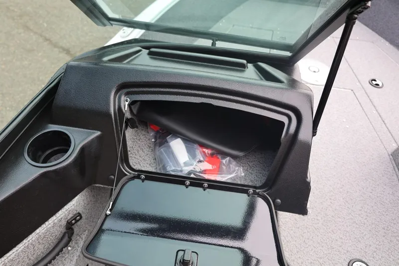 Slide: The Image of 2026 Lund 1775 Adventure Sport boat storage compartment with open hatch and cup holder. - 26