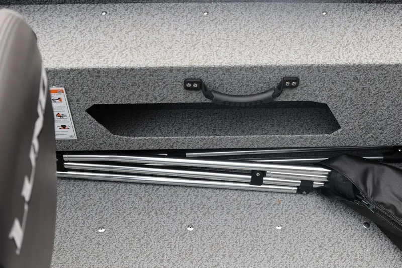Slide: The Image of 2026 Lund 1775 Adventure Sport boat interior storage compartment with metal rods. - 29