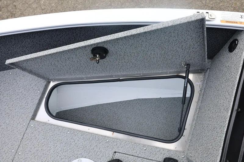 Slide: The Image of Open storage compartment in 2026 Lund 1775 Adventure Sport boat, featuring a secure latch and hydraulic support. - 36