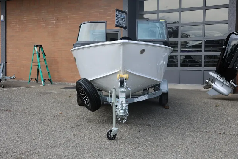 Slide: The Image of 2026 Lund 1775 Adventure Sport boat on trailer outside a garage. - 6