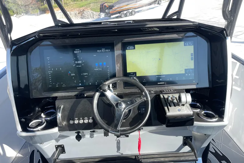 Slide: The Image of 2025 Nor-Tech 340 Sport Center Console dashboard with dual Garmin displays and steering wheel. - 17