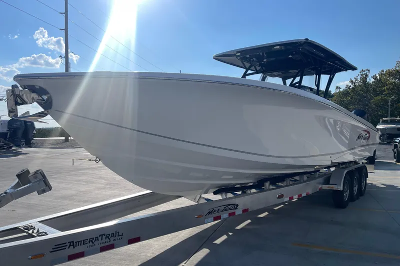 Slide: The Image of 2025 Nor-Tech 340 Sport Center Console boat on trailer under sunny sky. - 7