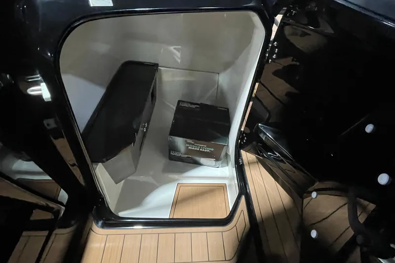 Slide: The Image of Storage compartment inside 2026 Yamaha Boats 275SD, featuring sleek design and wooden flooring. - 11