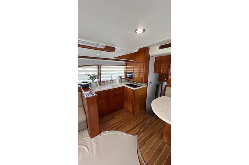 Slide: The Image of Luxurious interior of 2005 Bertram 450 yacht with modern kitchen and wooden finishes. - 10