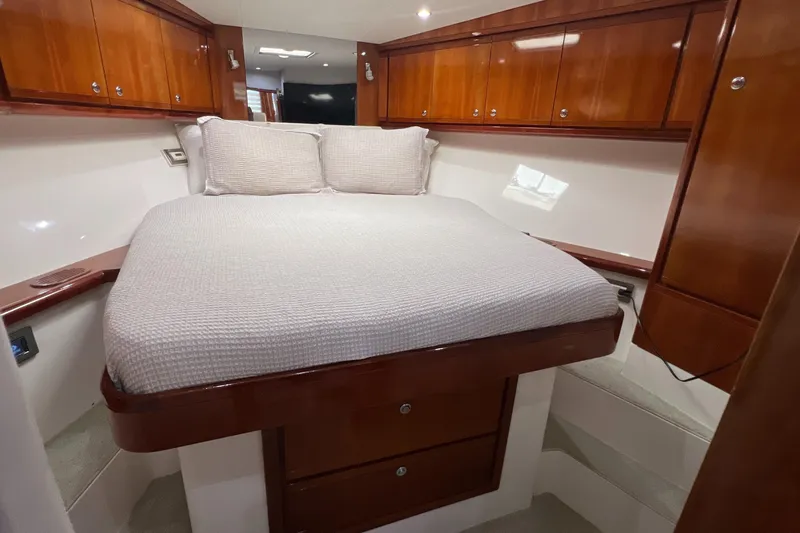 Slide: The Image of Luxurious cabin interior of a 2005 Bertram 450 yacht with wooden cabinetry and cozy bedding. - 13