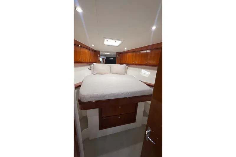 Slide: The Image of Interior of 2005 Bertram 450 yacht with cozy bed and wooden cabinets. - 14