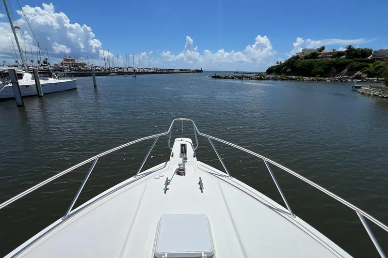 Slide: The Image of Bow view from a 2005 Bertram 450 yacht entering a marina under a clear blue sky. - 29