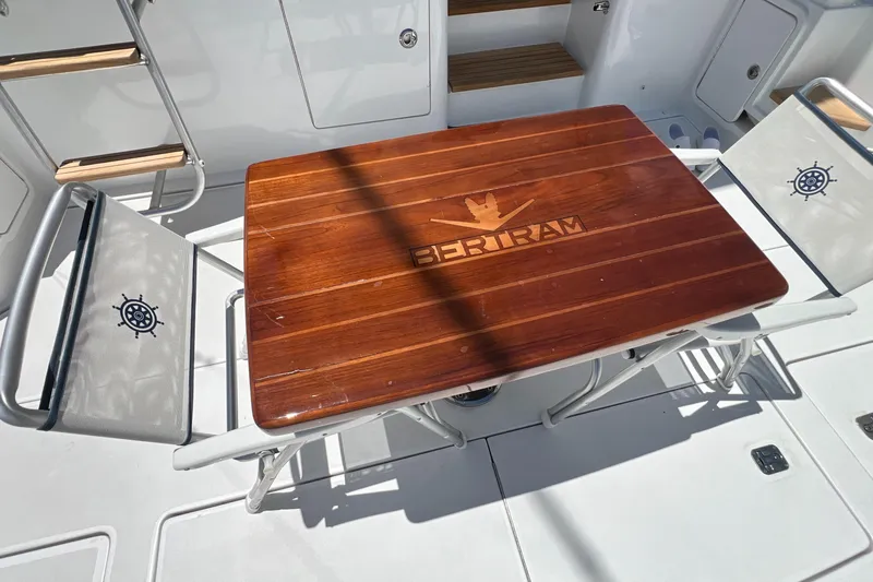 Slide: The Image of Bertram 450 yacht deck with wooden table and nautical-themed chairs, 2005 model. - 32