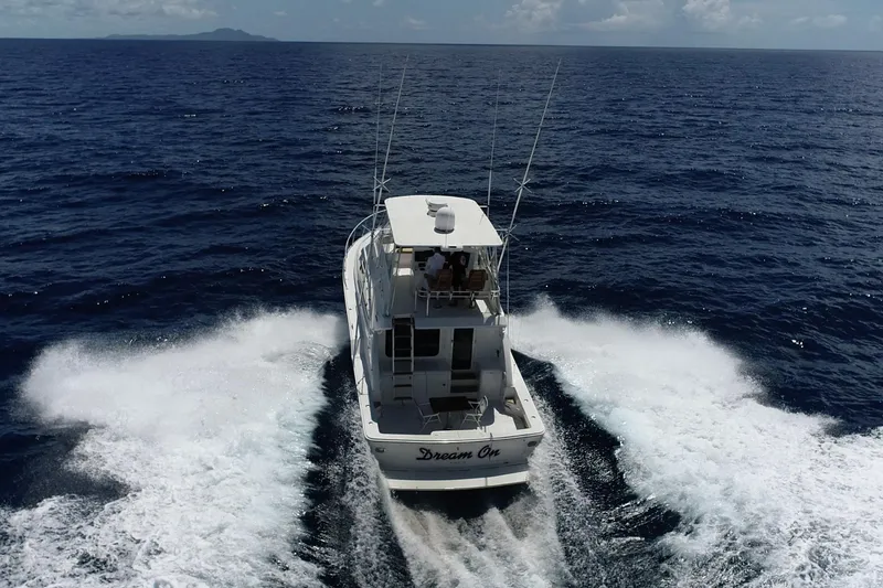 Slide: The Image of 2005 Bertram 450 yacht cruising on open ocean, creating a wake behind. - 37