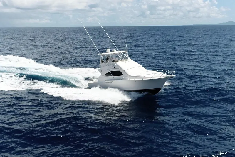 Slide: The Image of 2005 Bertram 450 yacht cruising on open ocean under clear skies. - 38