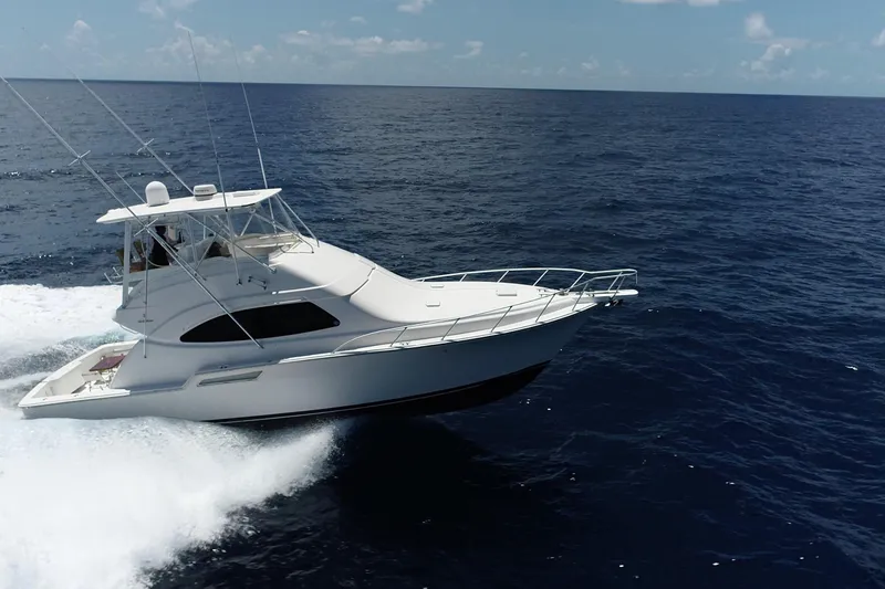 Slide: The Image of 2005 Bertram 450 yacht cruising on open ocean under clear sky. - 42