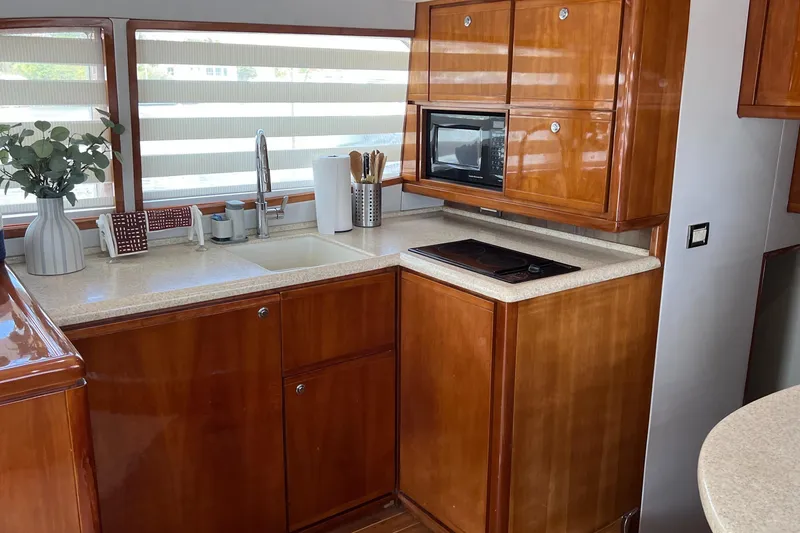 Slide: The Image of Luxurious kitchen interior of 2005 Bertram 450 yacht with wooden cabinets and modern appliances. - 5