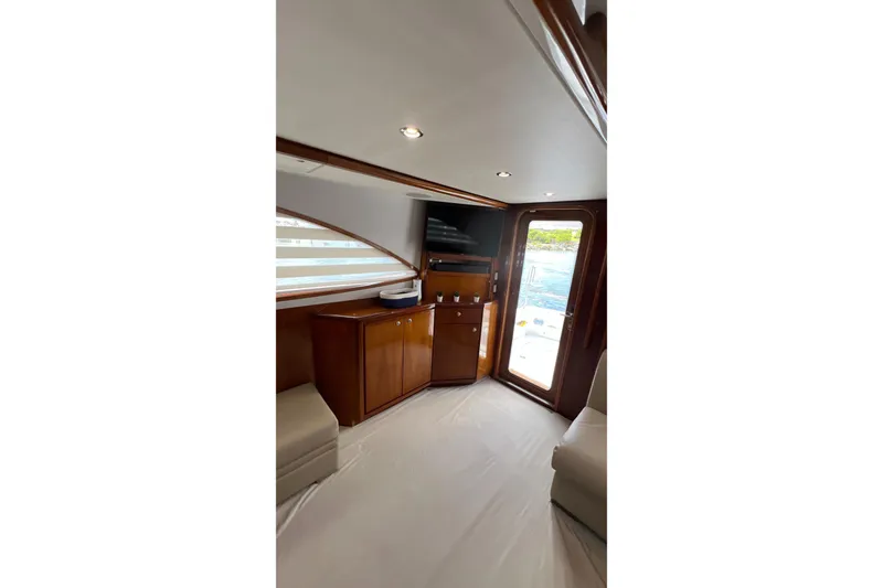 Slide: The Image of Interior of 2005 Bertram 450 yacht with wooden cabinetry and a view of the sea. - 8