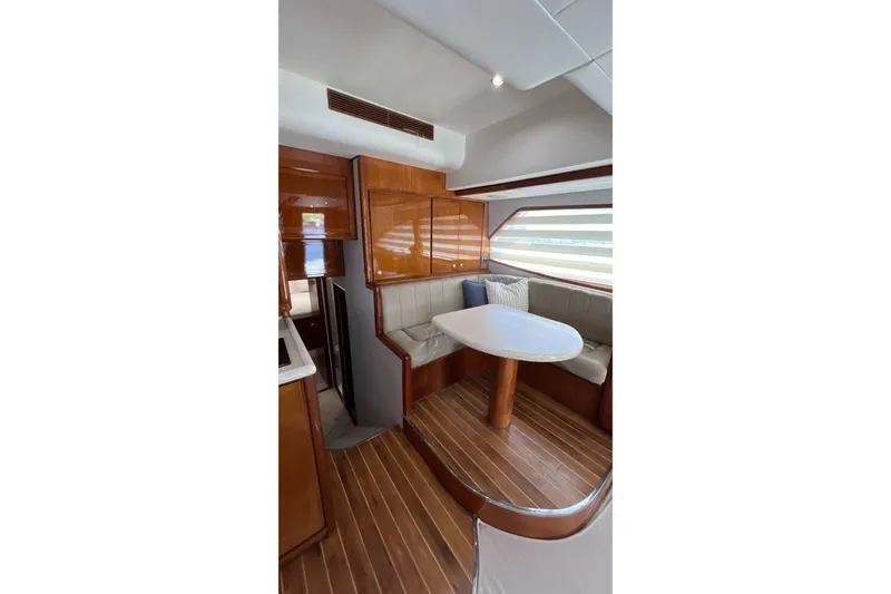 Slide: The Image of Interior of 2005 Bertram 450 yacht with wooden flooring and cozy dining area. - 9