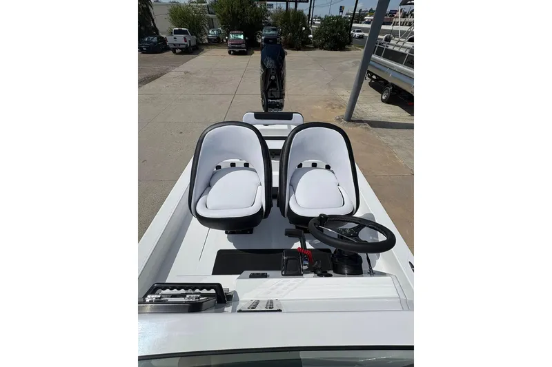 Slide: The Image of 2026 Mamba 24 Cat Elite boat interior with dual white seats and steering wheel. - 8