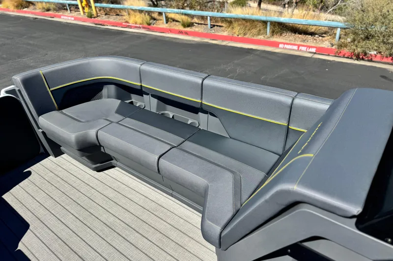 Slide: The Image of Luxurious seating on 2025 Manitou EXPLORE 24 boat, featuring sleek gray upholstery with yellow accents. - 11
