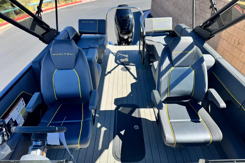 Slide: The Image of 2025 Manitou EXPLORE 24 boat interior with blue seats and yellow accents. - 12