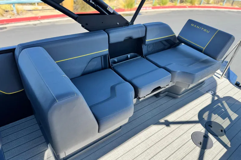 Slide: The Image of 2025 Manitou EXPLORE 24 boat interior seating with modern design and blue upholstery. - 14