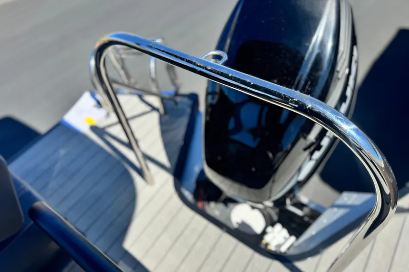 Slide: The Image of 2025 Manitou EXPLORE 24 boat deck with sleek railing and outboard motor. - 19